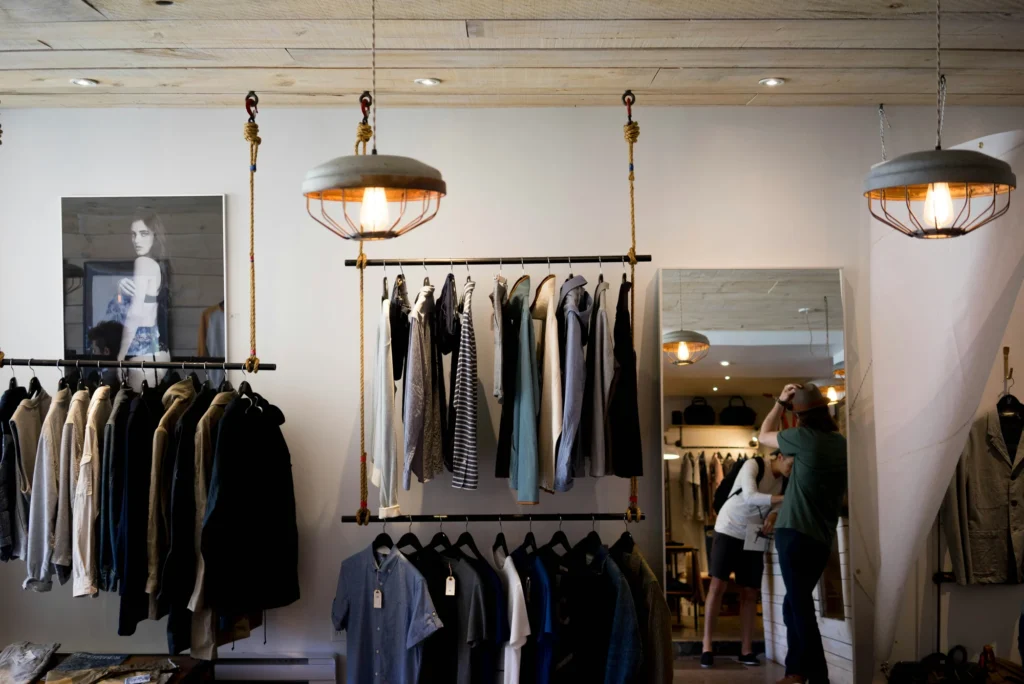 Intérieur de la boutique Clark Street Mercantile à Montréal, avec portants de vêtements et un grand miroir.